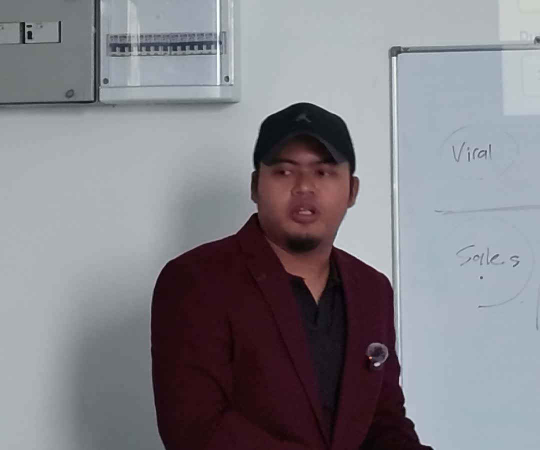 Coach Am berkongsi idea content di hadapan papan putih dalam sesi coaching